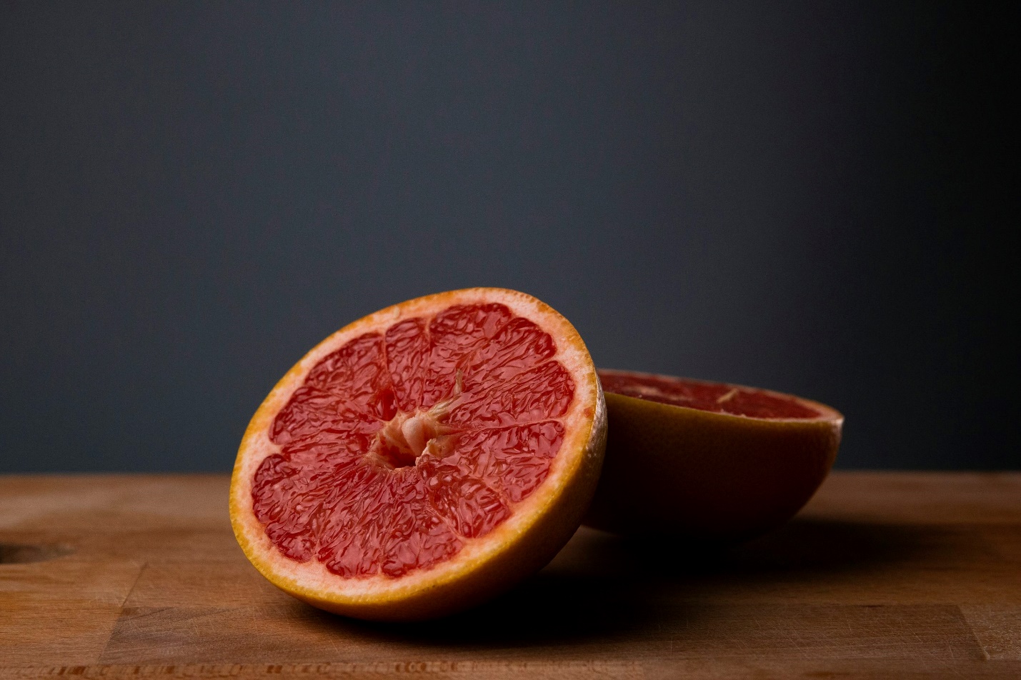 sliced orange fruit on brown wooden table